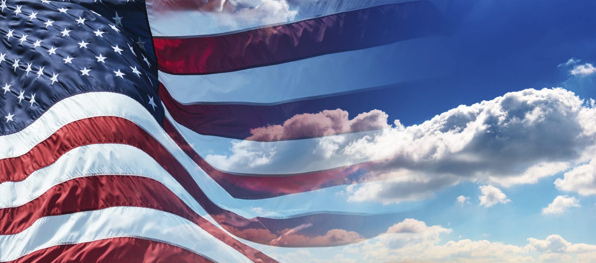 American flag with blue sky and clouds