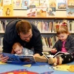 Man reading to baby and preschool child