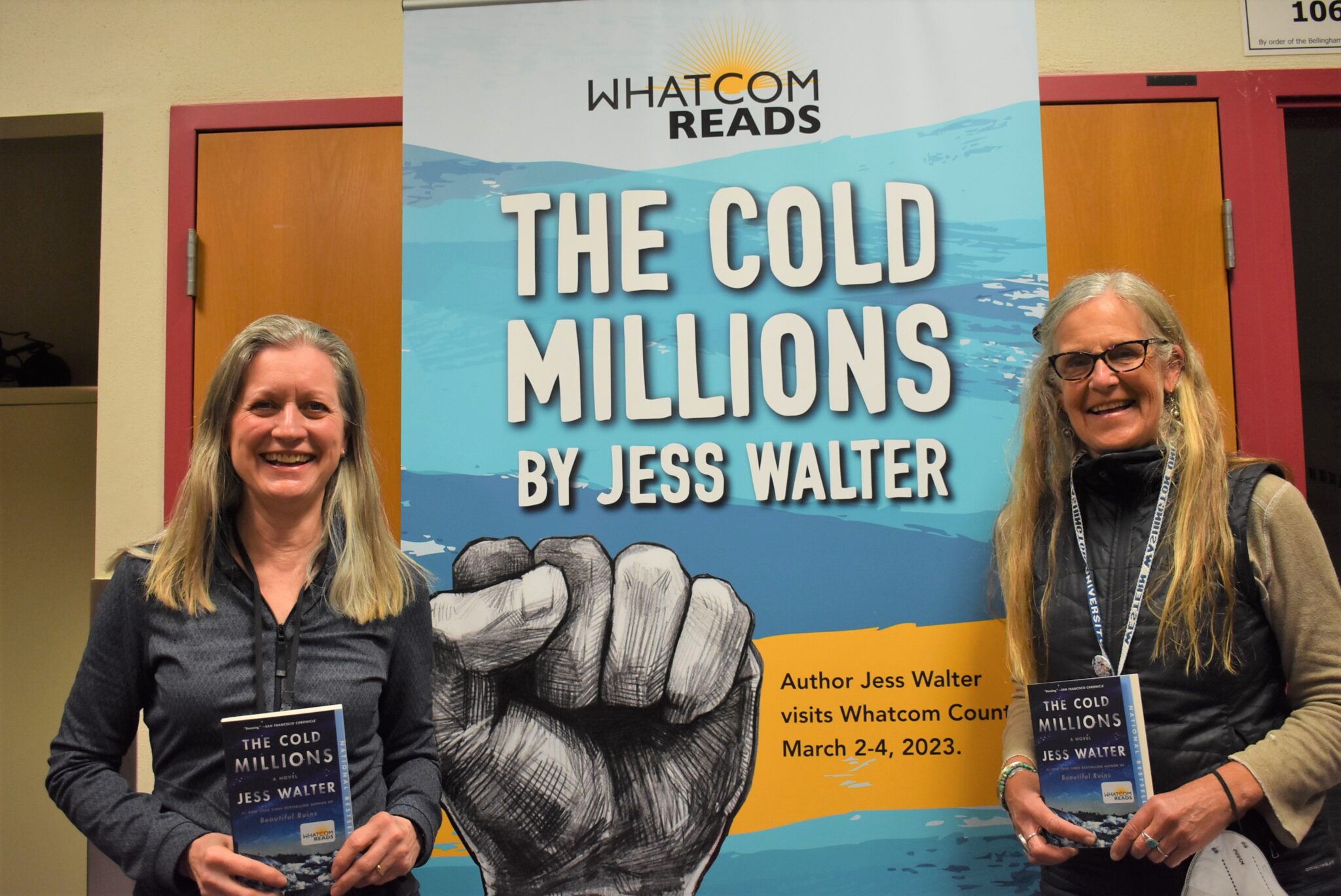 Two women hold copies of the book The Cold Millions