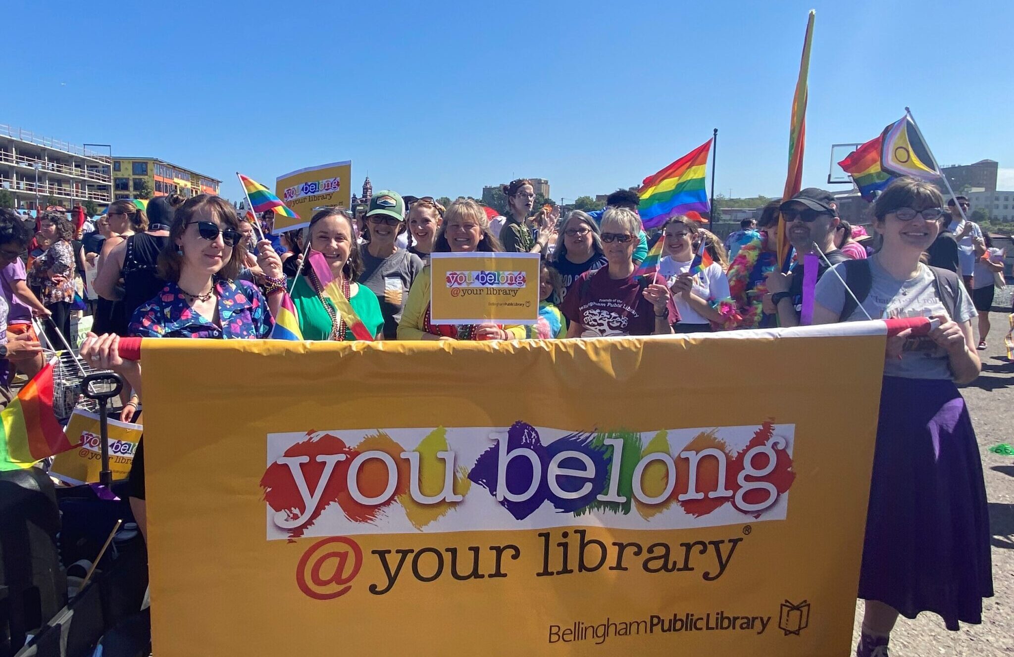 Library staff hold parade banner that reads You Belong at Your Library