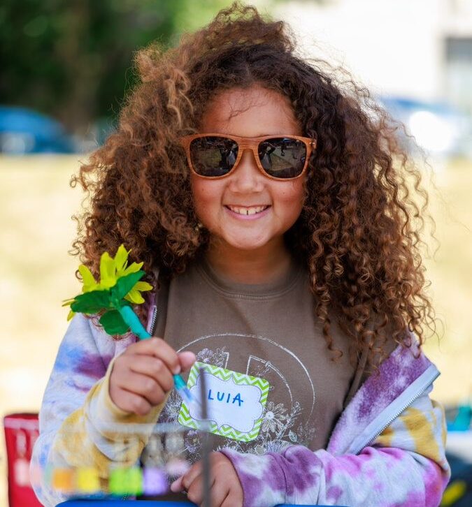 Child selling flower pens at Children's Craft Fair