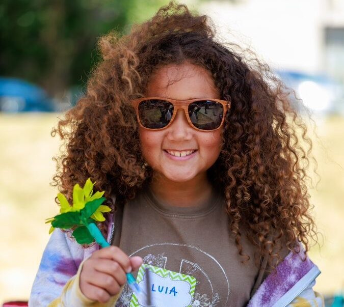 Child selling flower pens at Children's Craft Fair