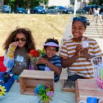 Three kids holding items for sale at Children's Craft Fair
