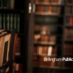 Image is of a dark library filled with old books