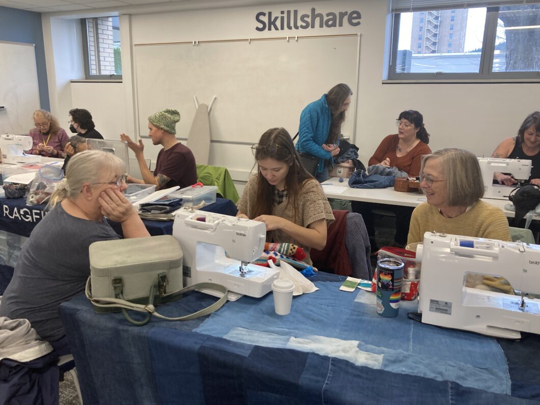 adults using sewing machines in Skillshare room