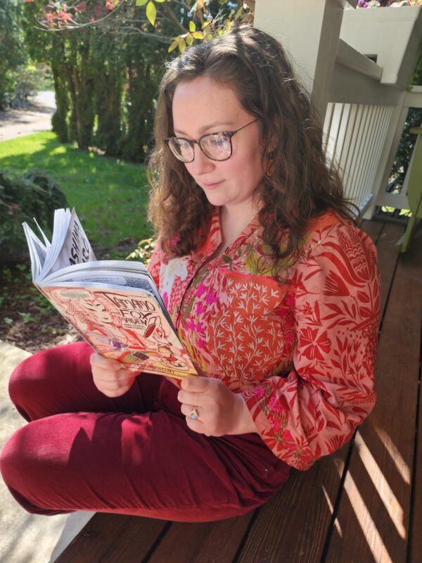 Person reading a book outside on a porch in the sunshine
