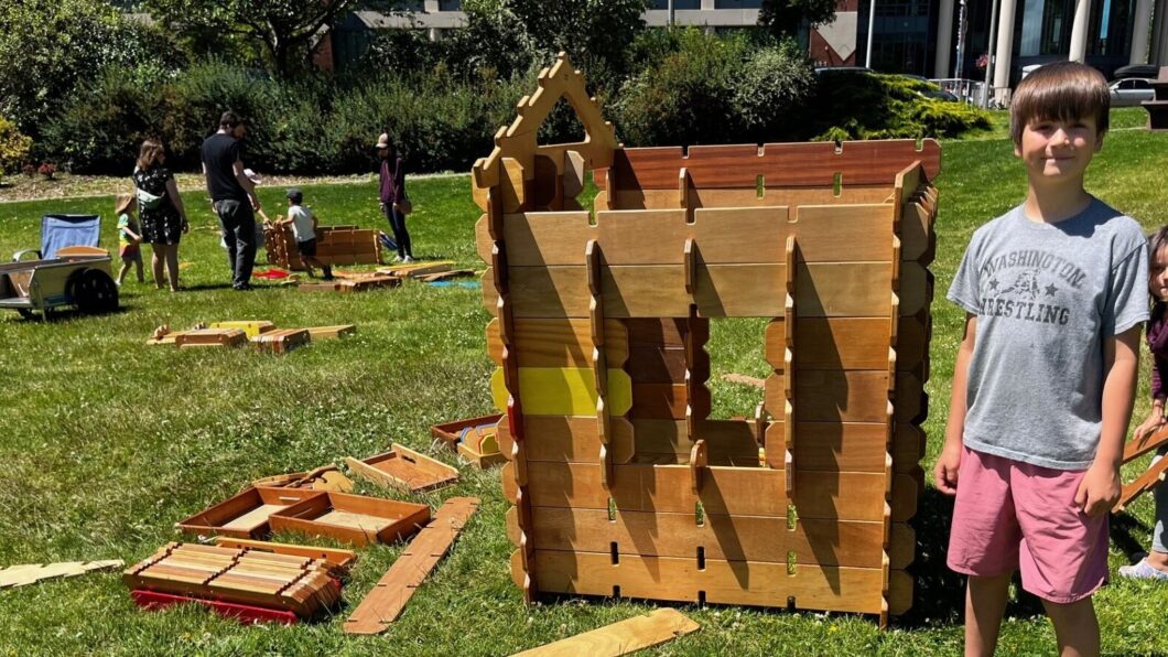 Child using builder boards to create a fort
