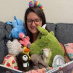 Librarian surrounded by stuffed animals.
