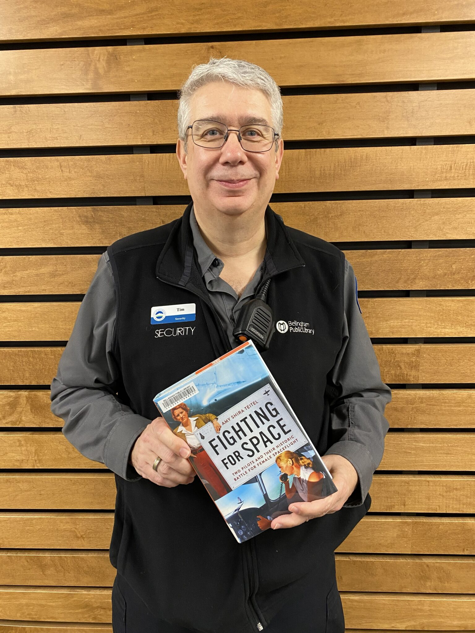 BPL staff member holding the book Fighting for Space by Amy Shira Teitel