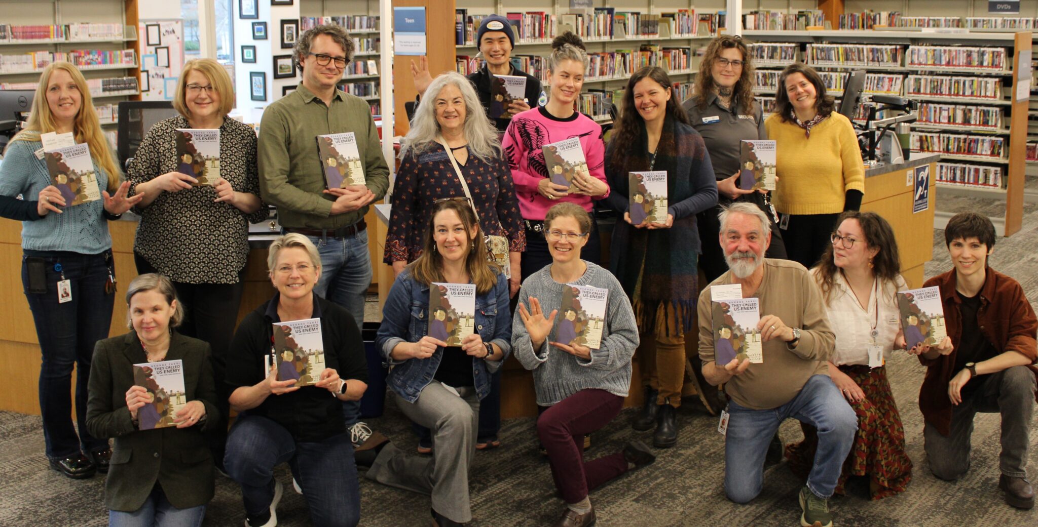 Library staff holding up books