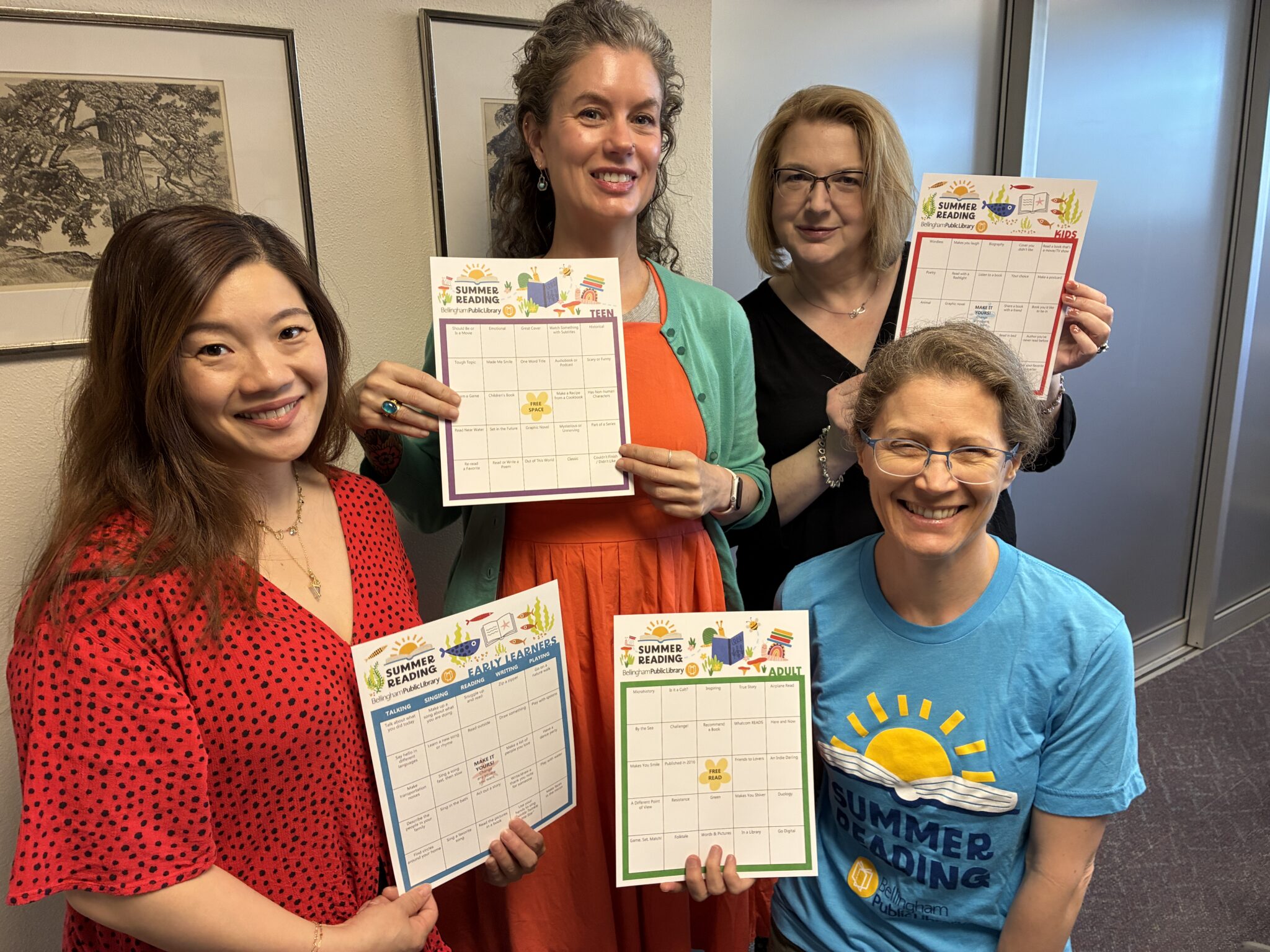 Four librarians holding summer reading cards