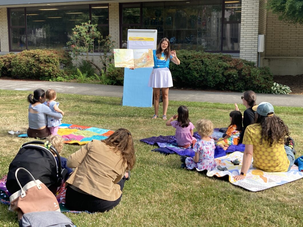 Librarian reading story to families outside