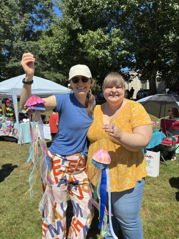 2 library staff members holding up their purchases