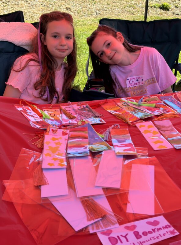 Two girls selling bookmarks