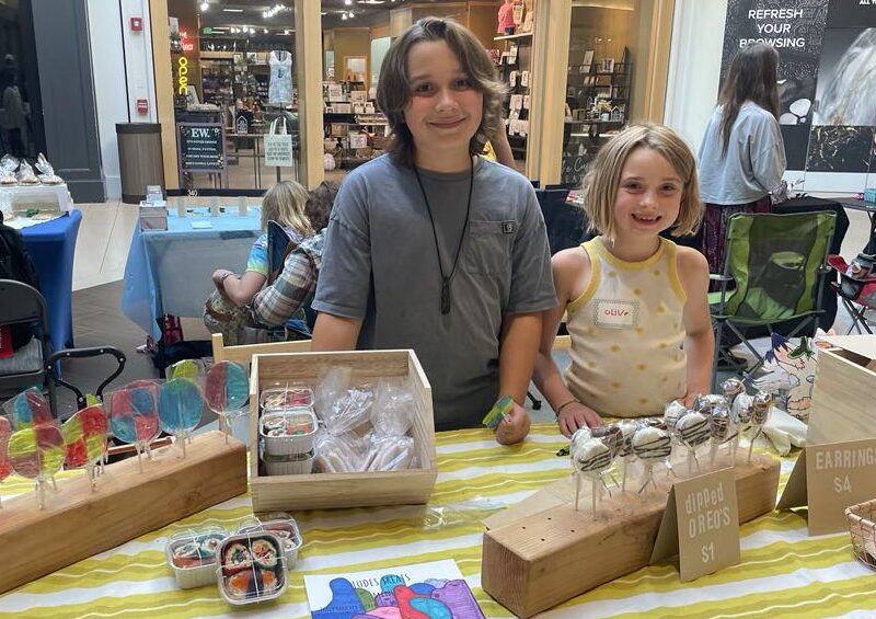 Two children selling handmade items at the Children's Craft Fair at the Bellis Fair Mall