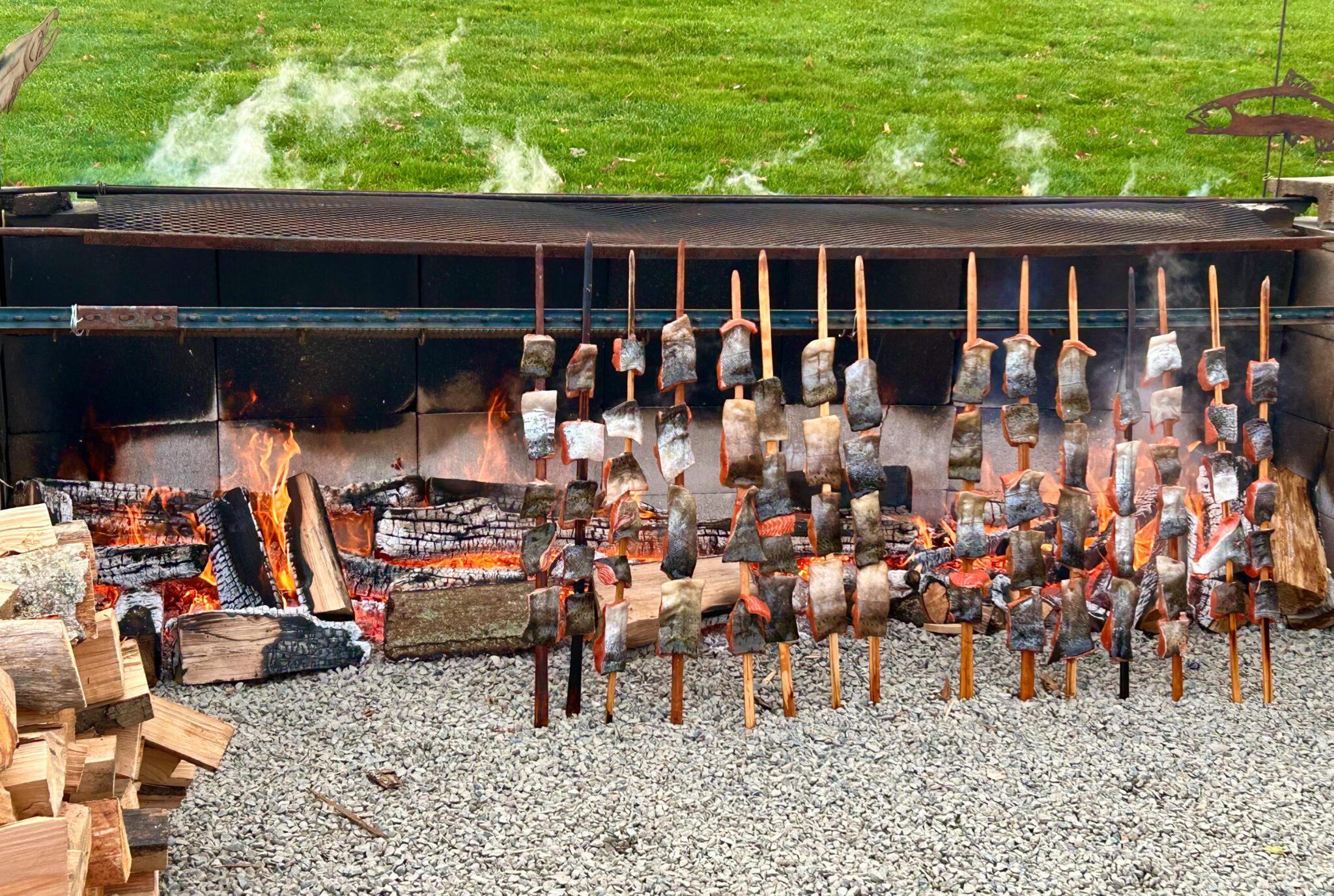 Salmon roasting on sticks