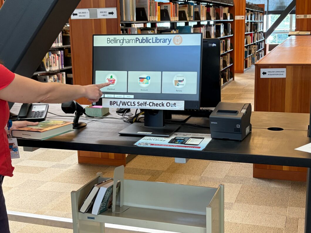 Person checking out books on computer screen at BTC