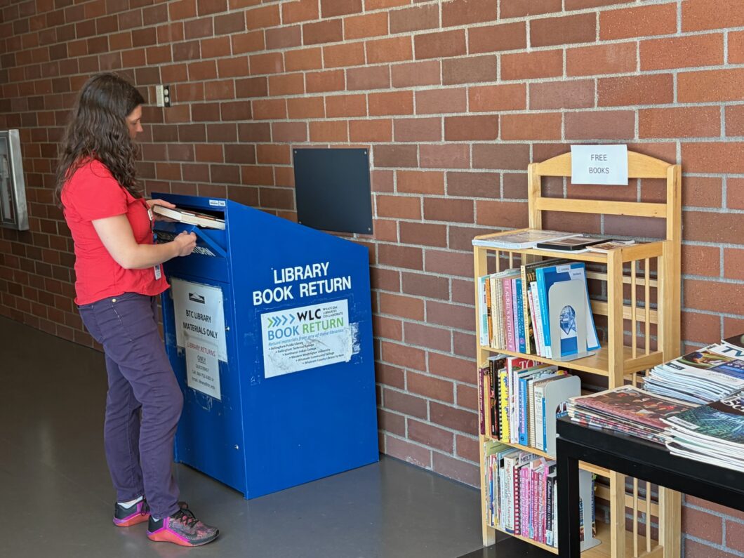 Person returning books to a blue returns box at BTC