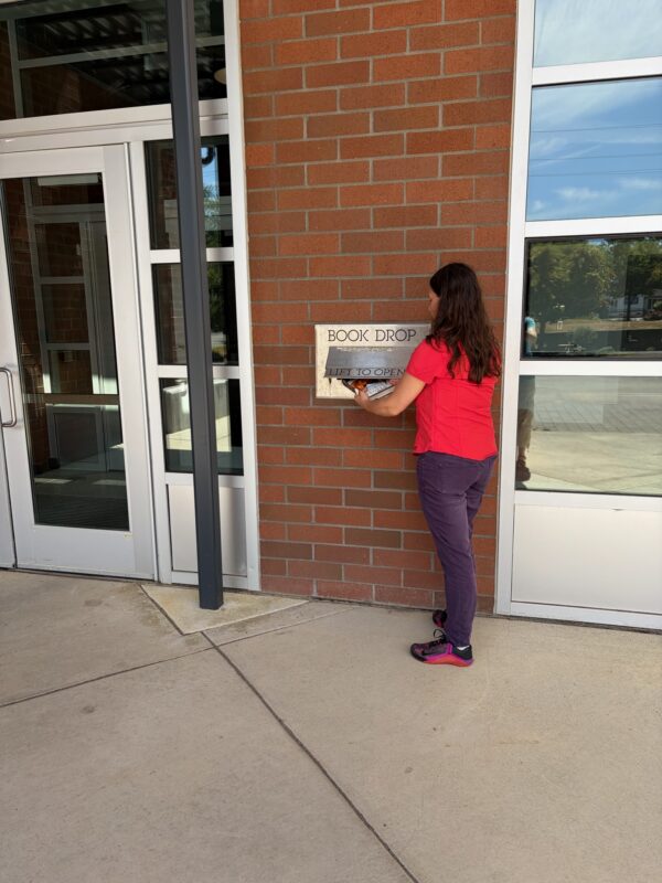 Person returning  books at outdoor book drop at BTC