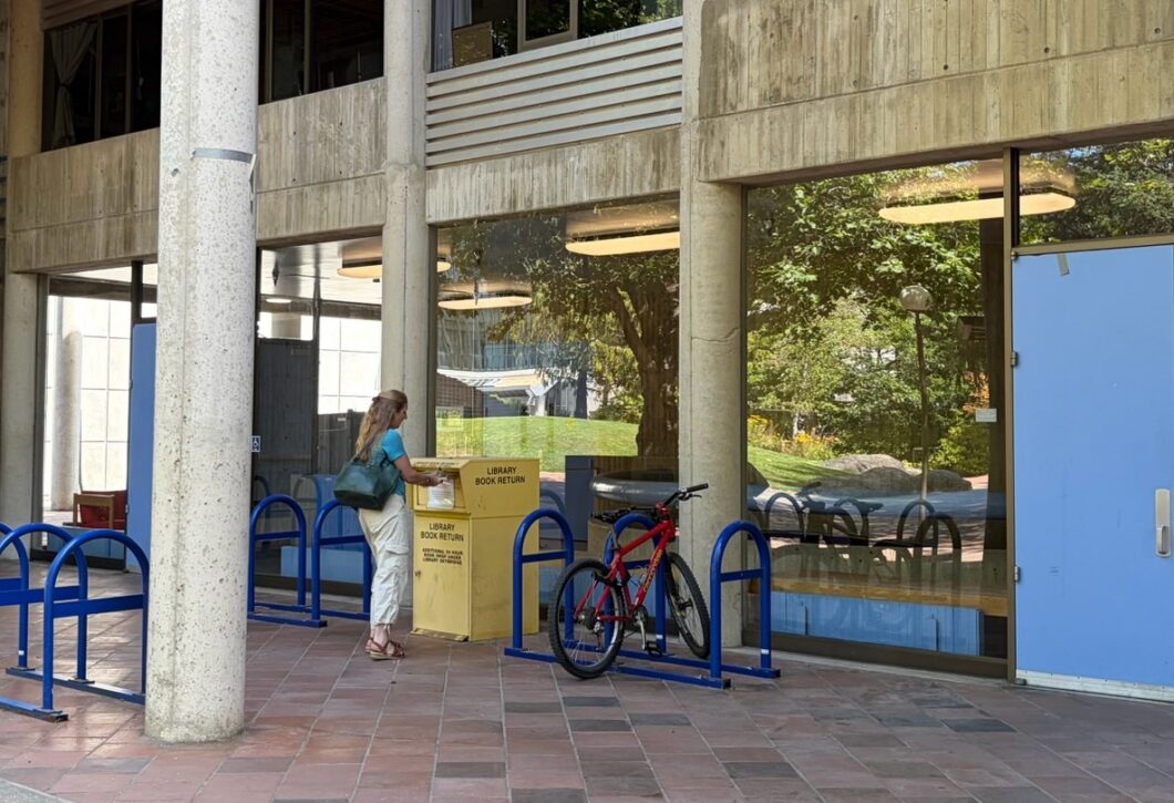 Person returning library books at yellow book return