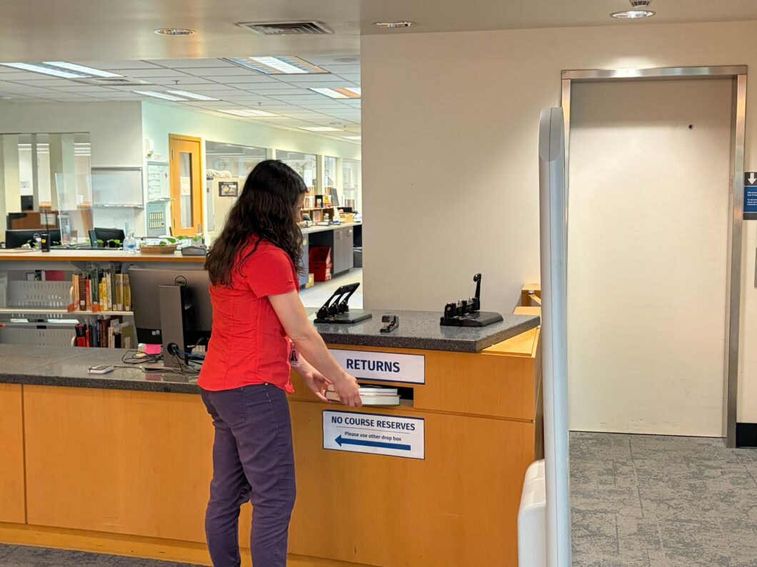 Person returning books inside WWU Wilson Library