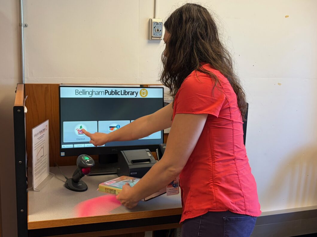 Person checking out Bellingham Public Library books at WWU Wilson Library